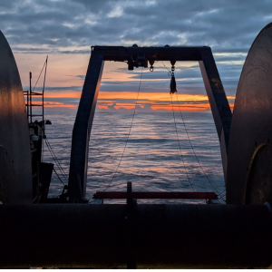 Sunset through net reel of research vessel